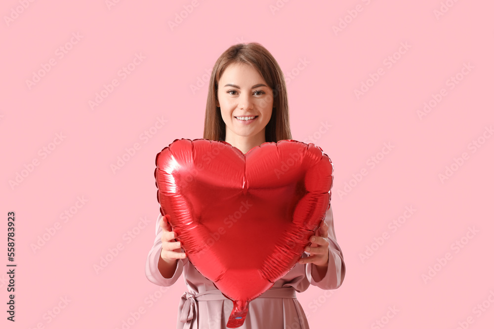 Young woman with balloon for Valentines Day on pink background