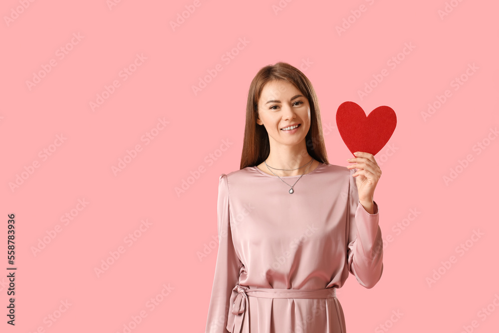 Young woman with paper heart for Valentines Day on pink background