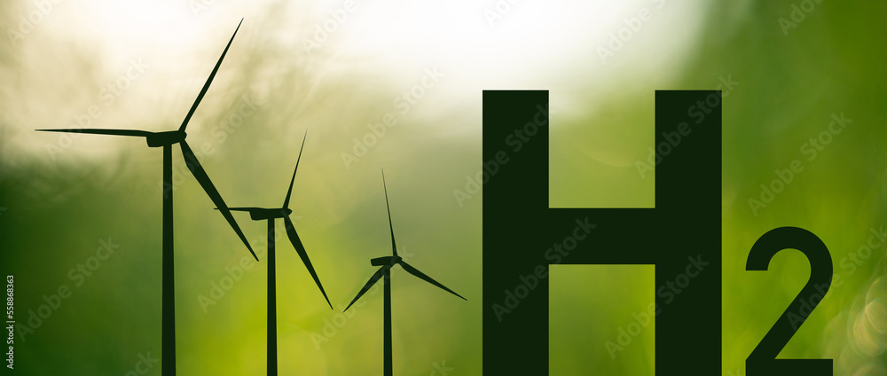 Silhouettes of Hydrogen symbol and wind turbines. Getting green hydrogen from renewable energy sourc