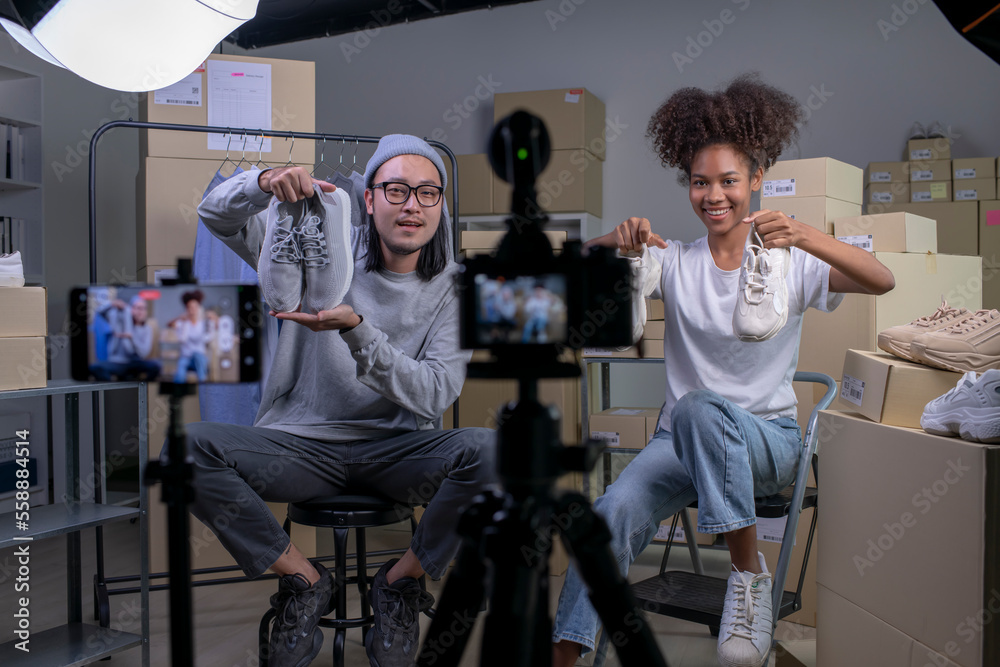 Mixed race couple of Asian man and African-American woman blogger or vlogger looking at camera revie