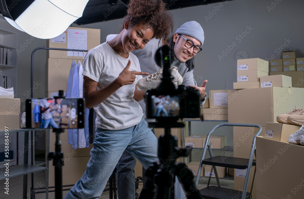 Mixed race couple of Asian man and African-American woman blogger or vlogger looking at camera revie