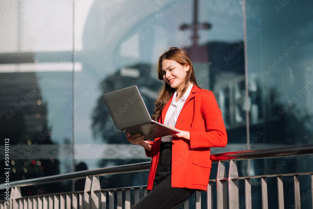 Portrait of Asian business woman holding laptop.Office worker at business center..