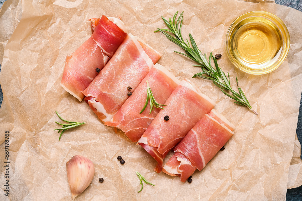 Baking paper with slices of tasty ham, spices and oil, closeup