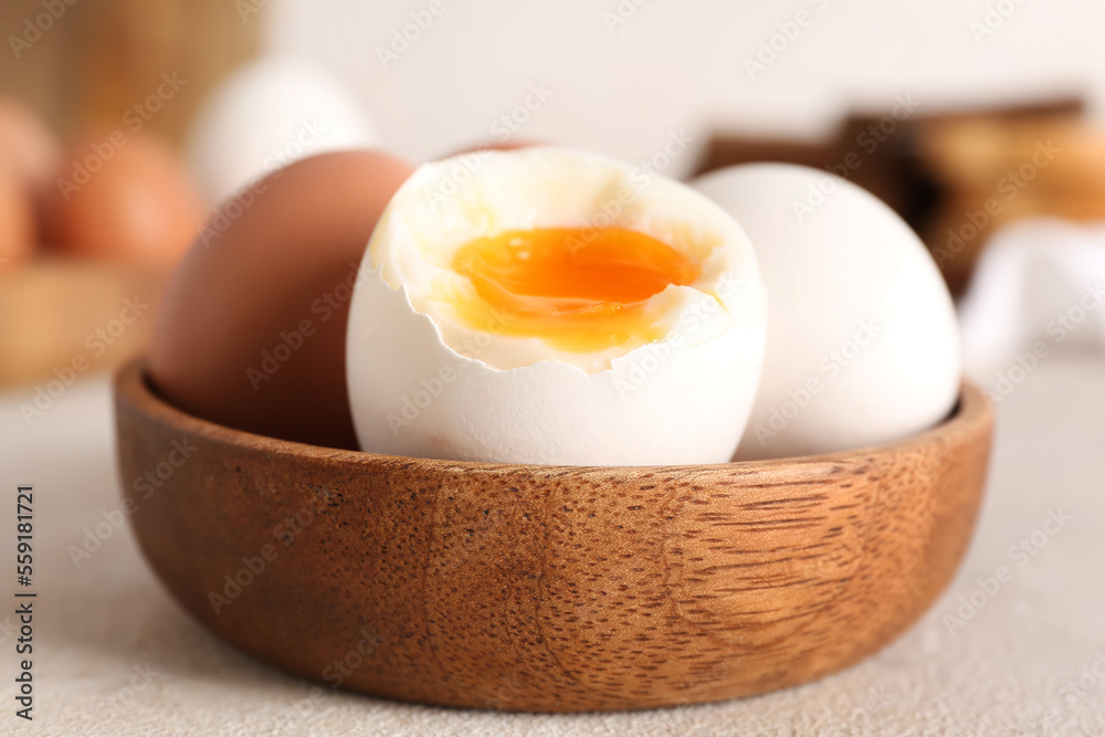 Bowl with soft boiled eggs on grey table