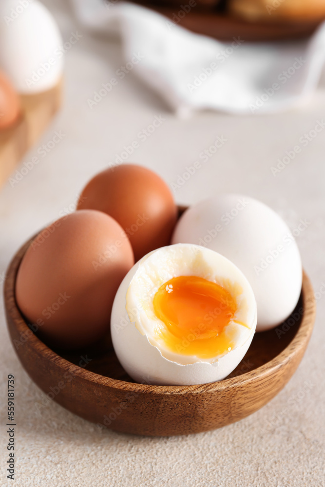 Bowl with soft boiled eggs on grey table