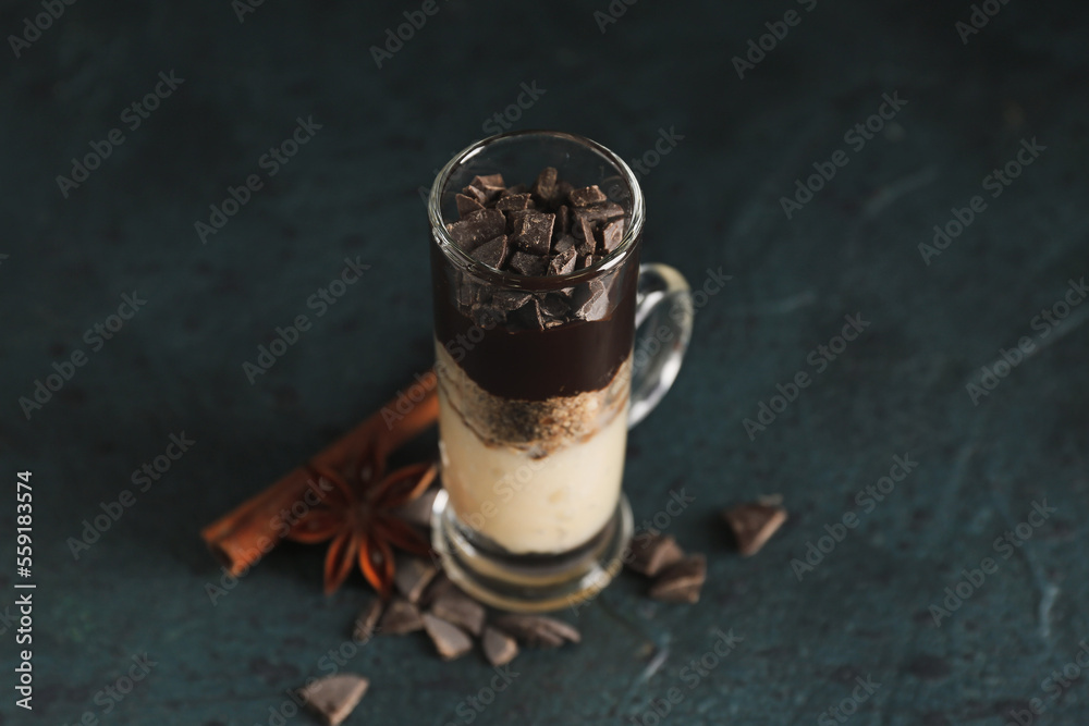 Shot of delicious pudding with chocolate, cinnamon and anise on black table