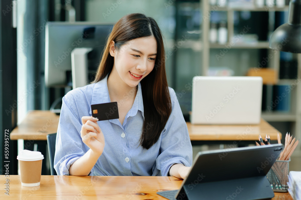 Asian Business woman hands holding credit card with digital layer effect diagram as Online shopping 