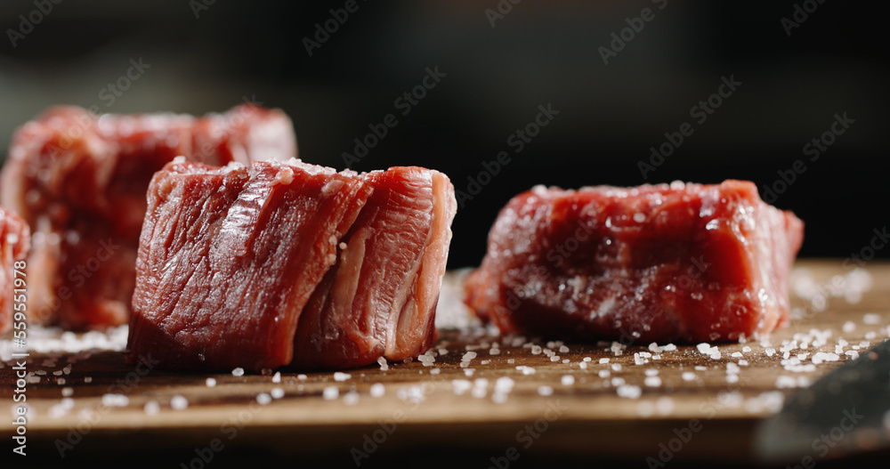 Small pieces of fresh beef on preparation table on professional kitchen. Juicy meat before grilling 