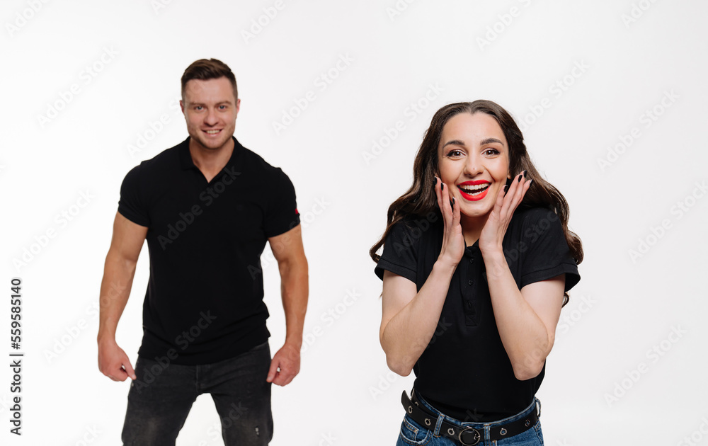 Young romantic couple posing on white. Cheerful emotional couple at isolated background.