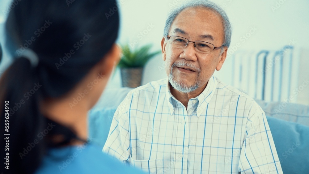 A young female doctor inquires about personal information of a contented senior at home. Medical car