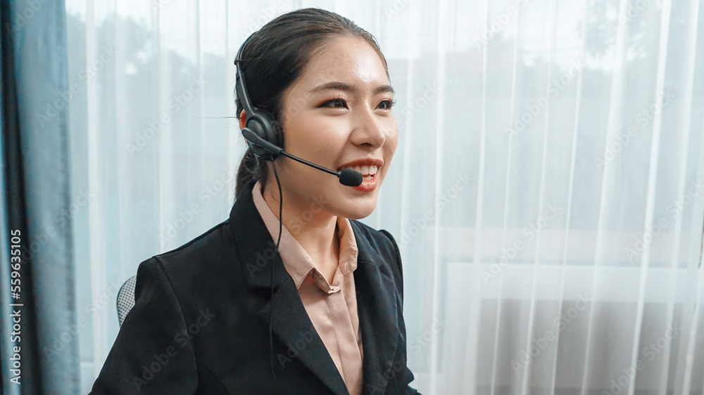 Young enthusiastic female operator put on headphone, looked into camera, and start working instantly