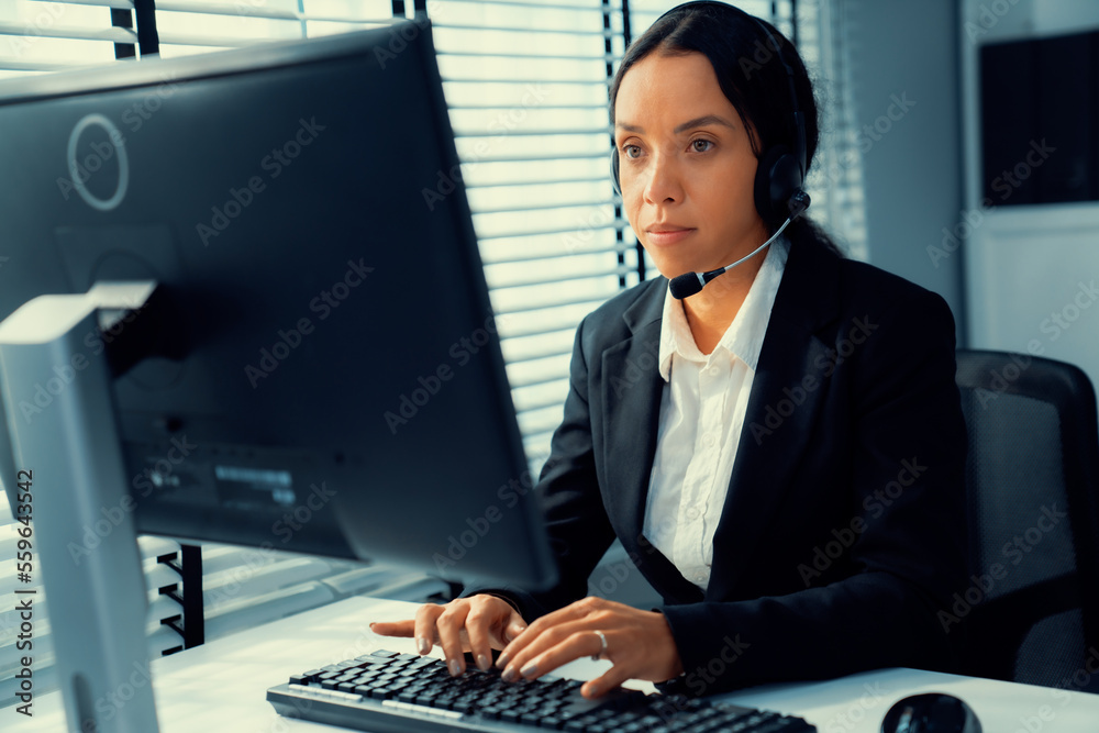 Competent female operator working on computer and talking with clients. Concept relevant to both cal