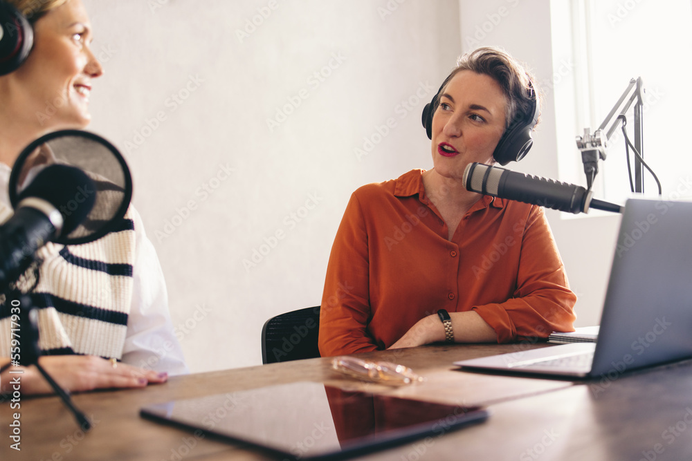 Female radio hosts having a conversation in a home studio