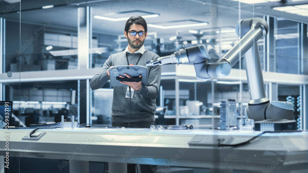 Robotics Engineer Researching and Developing a Technological Robot Arm Project, Standing with Tablet