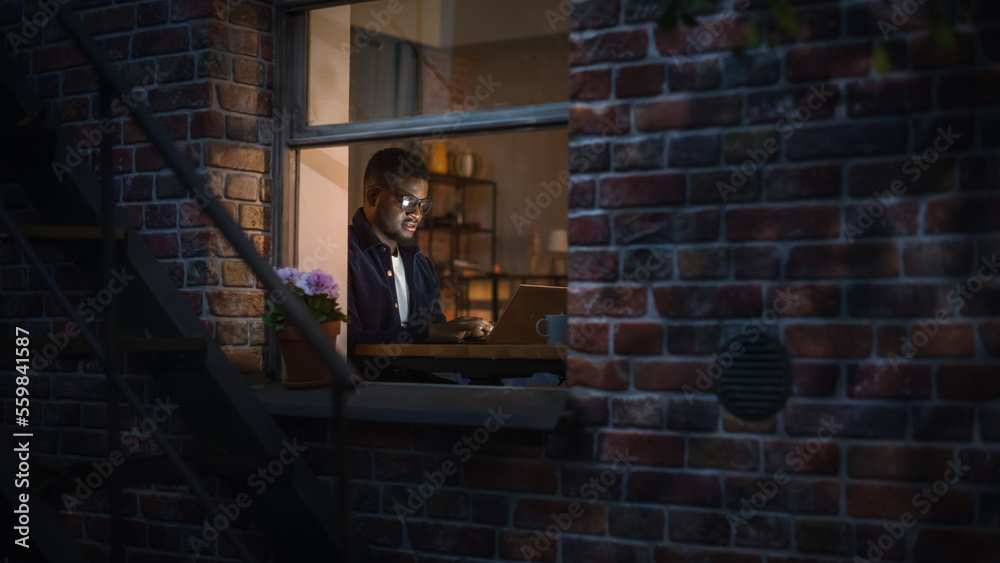 Portrait of Stylish Black Businessman Works on Laptop, Does Data Analysis While Working from Home at