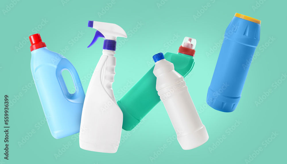 Flying bottles of detergents on color background