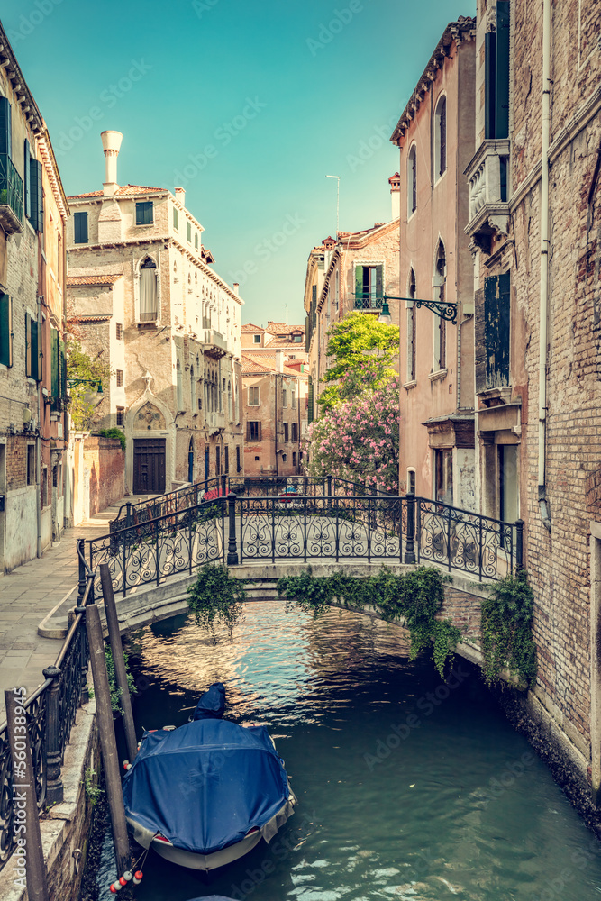 Romantic canal in Venice, Italy with scenic bridge and boat