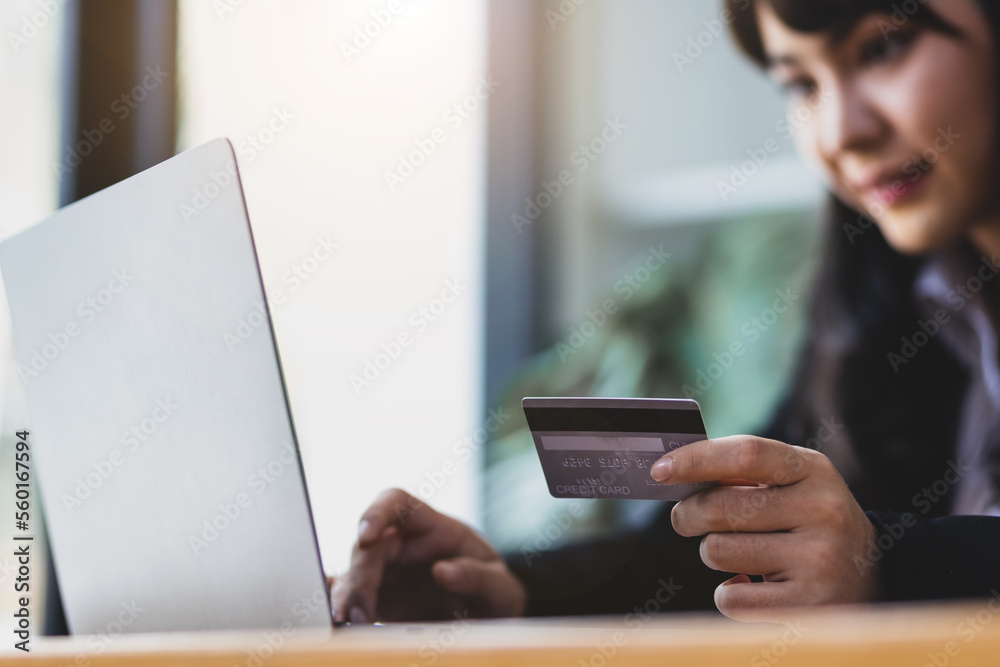 Woman holding credit card and using laptop. Online payment and online  shopping concept.