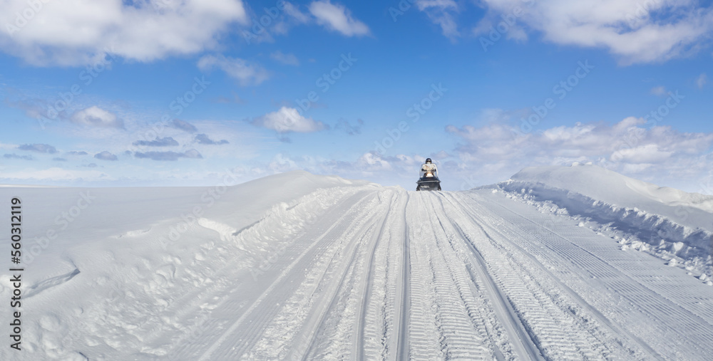 Snowmobile driving on a snow hill