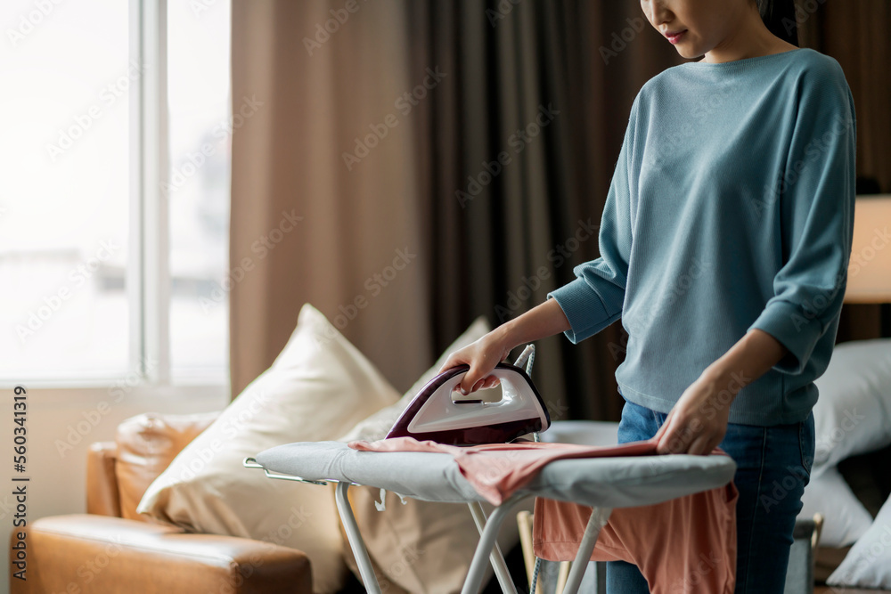 young asian adult female woman ironing her cloth at home,Portrait of a happy woman ironing her cloth