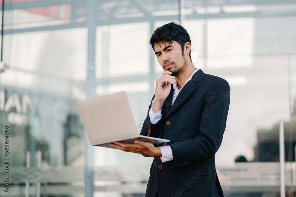 Portrait of Asian business man holding laptop.Office worker at business office.