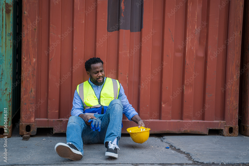 Worker sitting and thinking of something while taking a break after working at container yards.