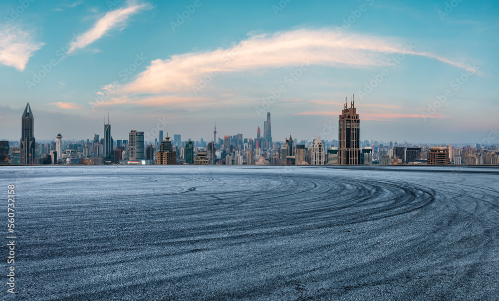 Asphalt road and city skyline with modern buildings in Shanghai at sunset, China.