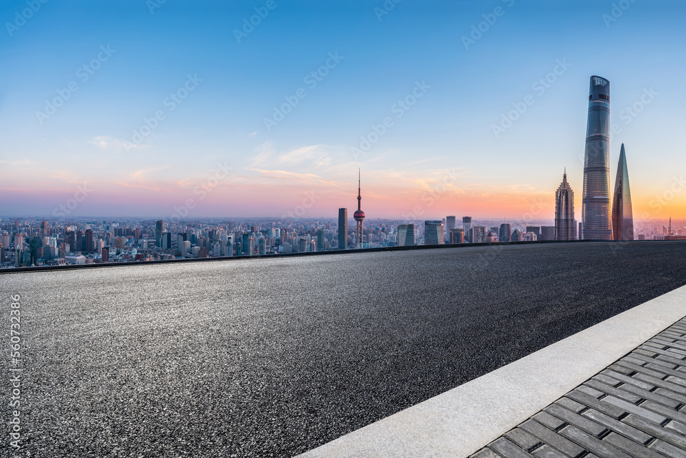 中国上海日出时的柏油路和城市天际线，以及现代化的建筑。