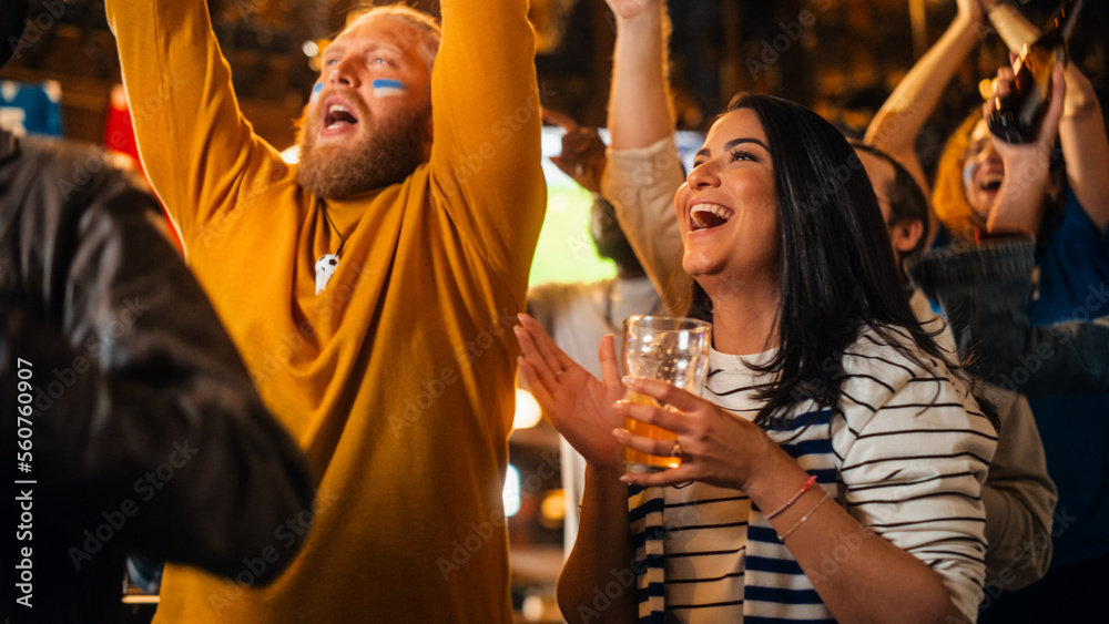 Group of Soccer Fans Watching a Live Football Match Broadcast in a Sports Pub on TV. People Cheering