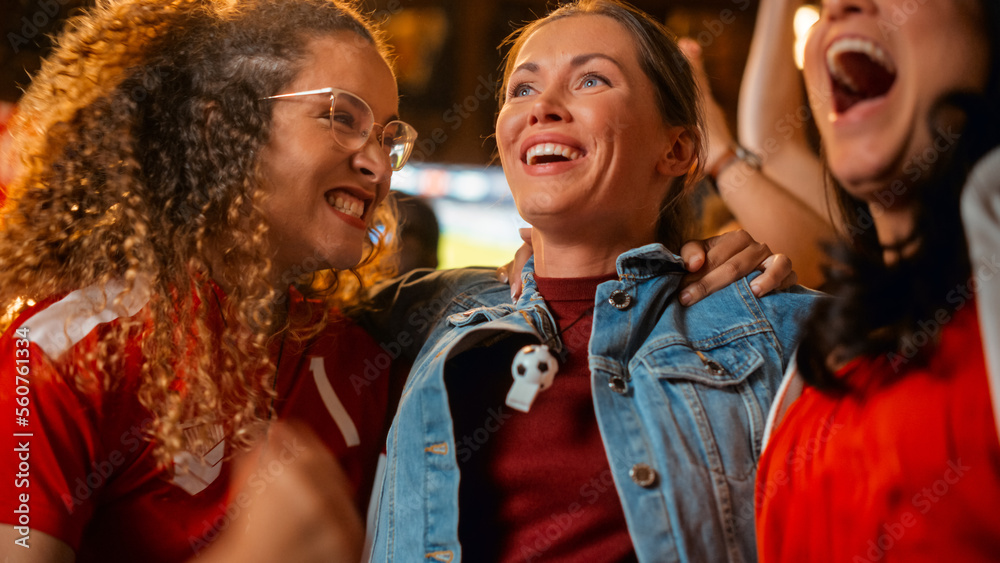 Three Female Friends Watching a Live Soccer Match on TV in a Sports Bar. Happy Girls Cheering and Sh