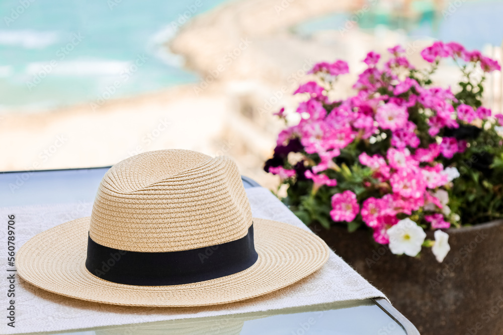 Table with summer hat on balcony, closeup