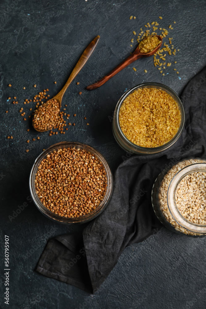 Jars with cereals on dark background