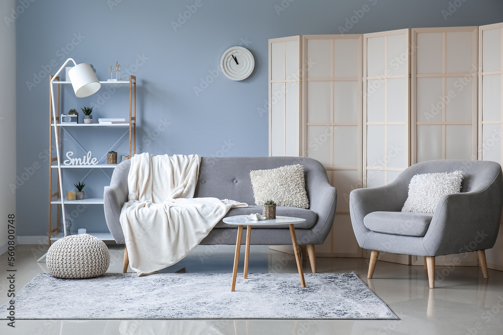 Interior of living room with sofa, armchair and folding screen