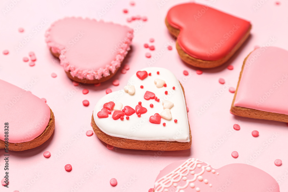 Composition with tasty heart shaped cookies and colorful sprinkles on pink background, closeup. Vale