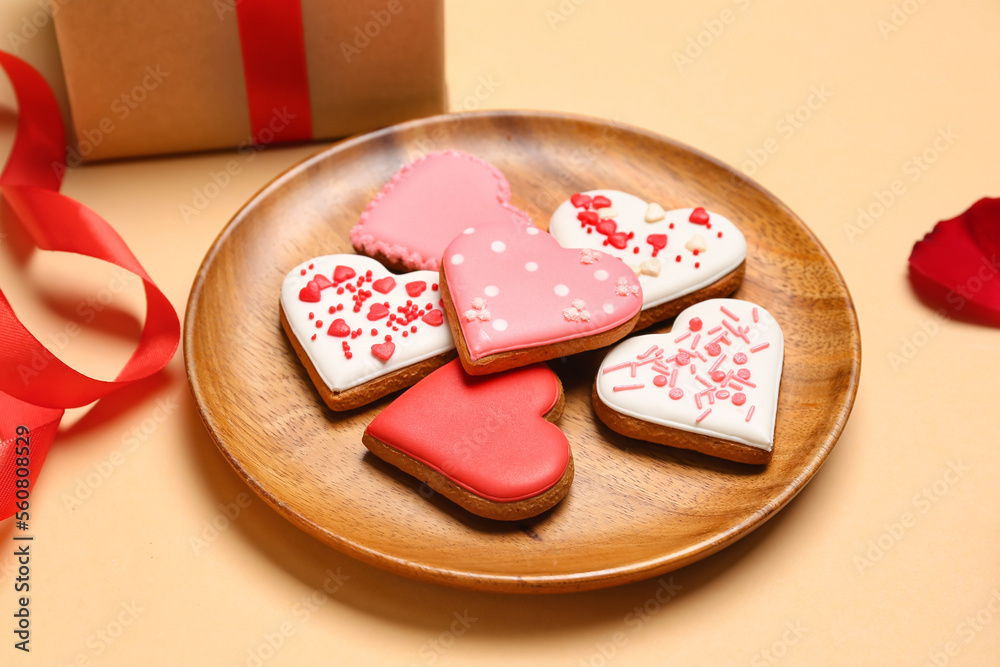 Wooden plate with tasty heart shaped cookies on color background. Valentines Day celebration