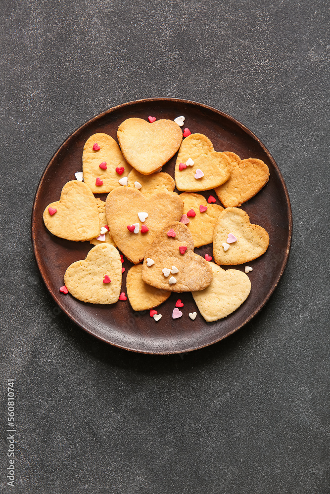 Plate of sweet heart shaped cookies on dark background. Valentines Day celebration