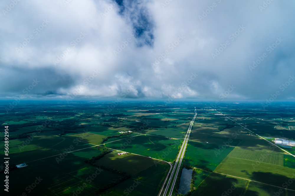 View on low clouds above huge fields. American view. Farmers fields.