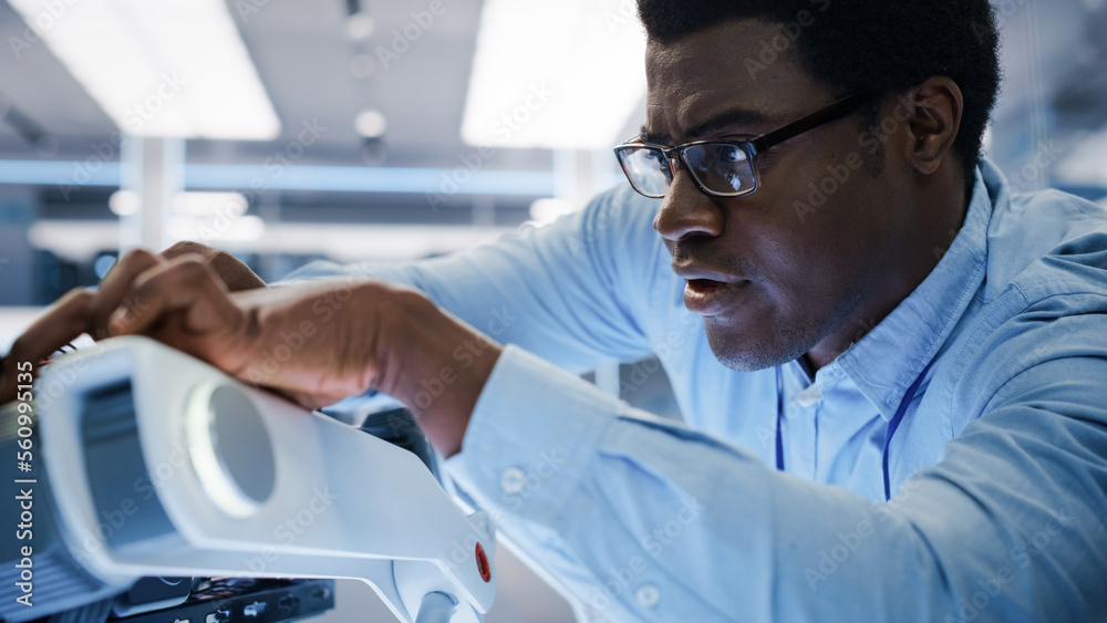 Close Up of an African Engineer Using a Screwdriver While Developing a Robot Dog Concept. Black Spec