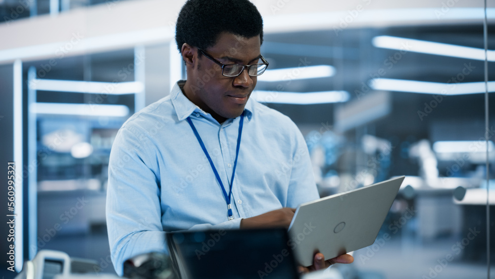 Handsome Black Man Wearing Glasses Using Laptop Computer. Young Intelligent Male Engineer or Scienti