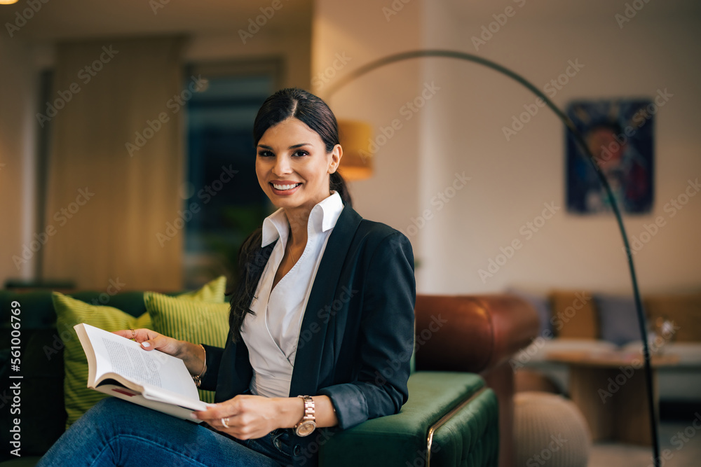 Portrait of a smiling businesswoman holding a notebook, sitting at the home office.