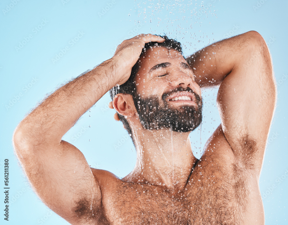 Shower, grooming and a man cleaning his hair with shampoo in studio on a blue background for beauty.