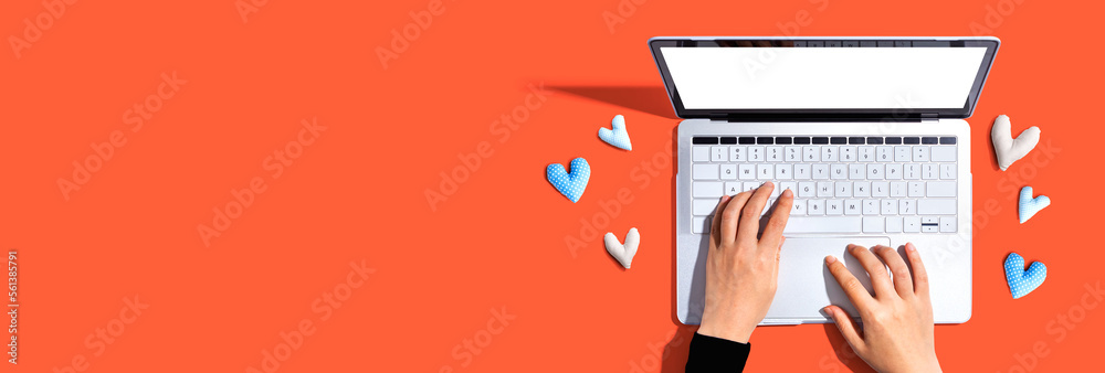 Laptop computer with heart cushions - flat lay