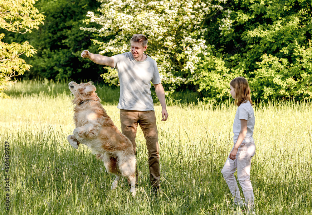 Dad and his daugter play with dog