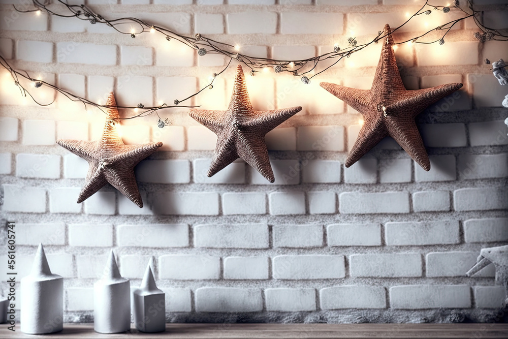 Christmas toys in the form of stars on dry tree branches in faded lights against a white brick wall.