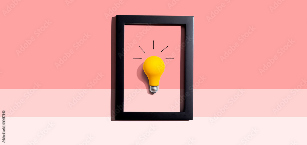 Yellow light bulb inside a frame - inspiration, creativity, energy, electricity themes