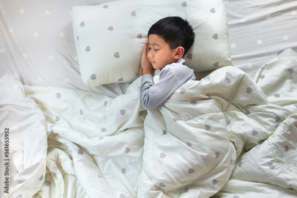 Top View of Asian boy having sweet dreams while Sleeping Cozily Bed