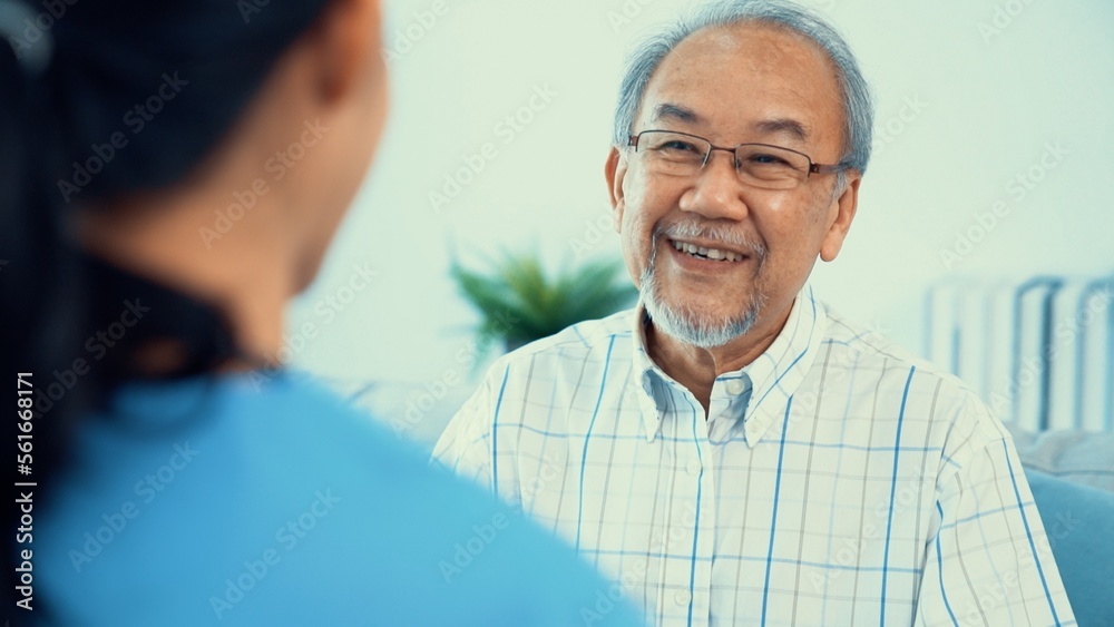 A young female doctor inquires about personal information of a contented senior at home. Medical car