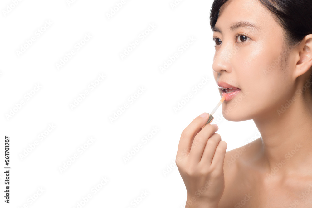 Beautiful portrait young asian woman looking mirror applying makeup lipstick at room