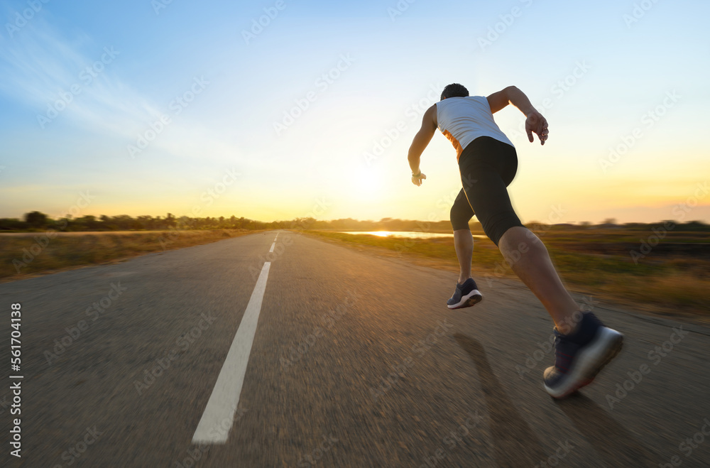 Action motion blur of a man running on country road with sunrise background...