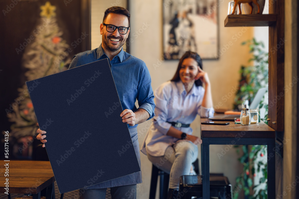 Coffee shop waiter holding blackboard